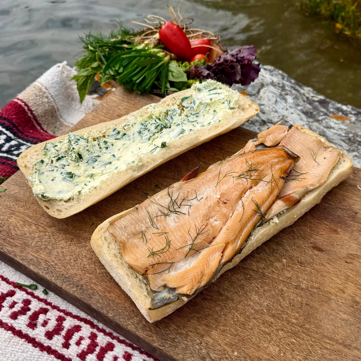 Smoked trout fillets laid in an even layer across the bottom half of the loaf and topped with sprigs of fresh dill