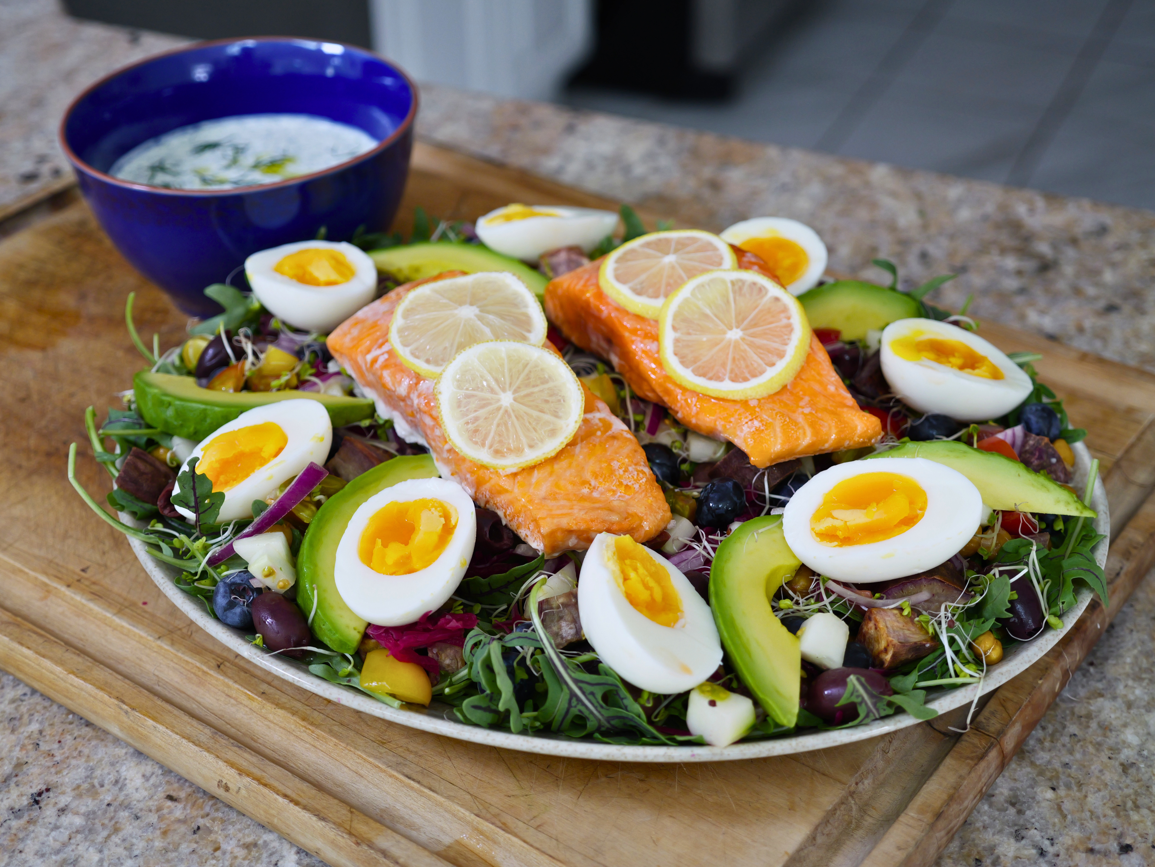 Centenarian Salmon Salad on a large platter with baked Seatopia salmon, jammy eggs, avocado and Okinawan sweet potatoes