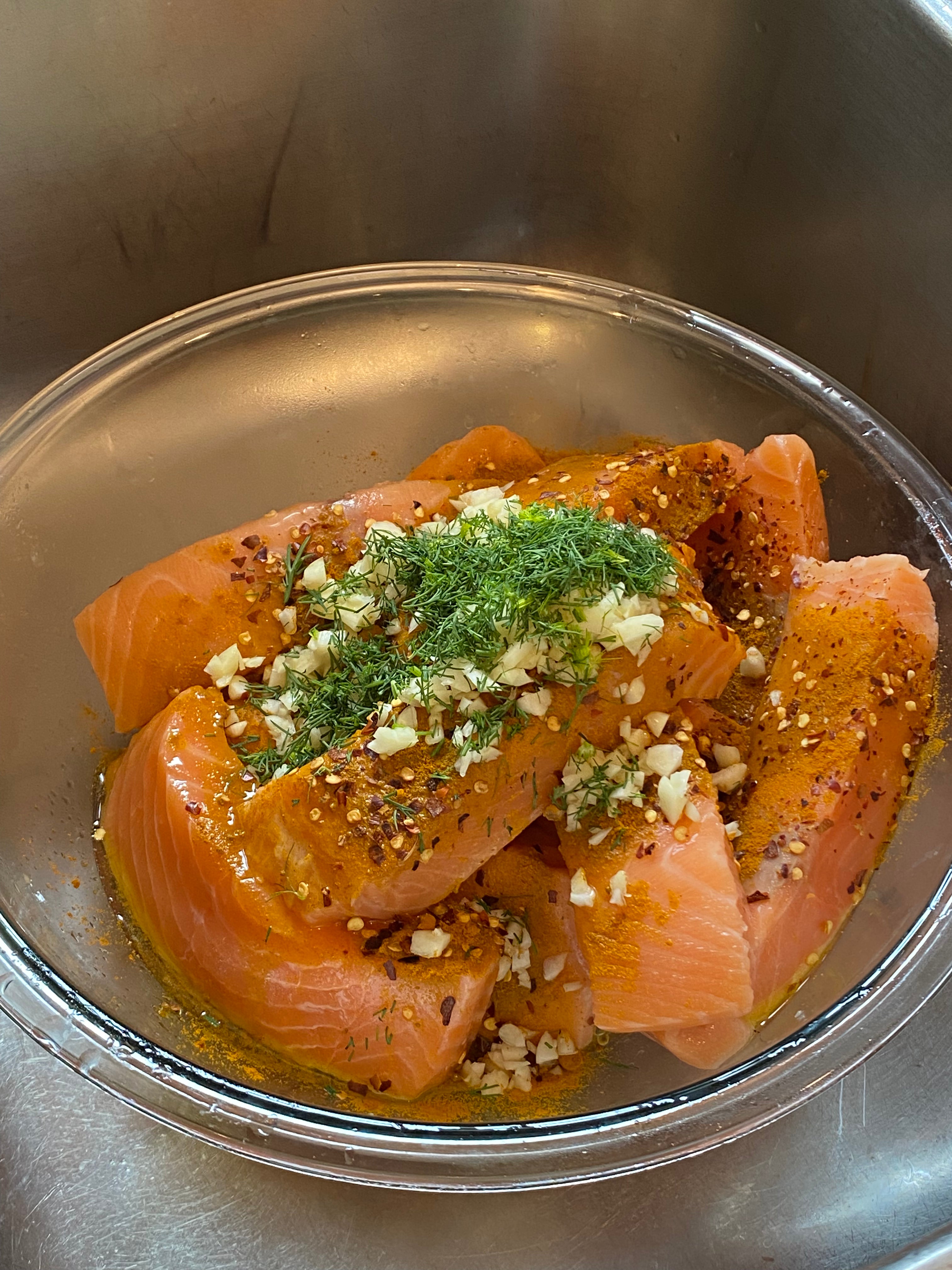 Minced garlic, chopped dill, chili flakes and ground turmeric tossed with Seatopia salmon portions in a mixing bowl
