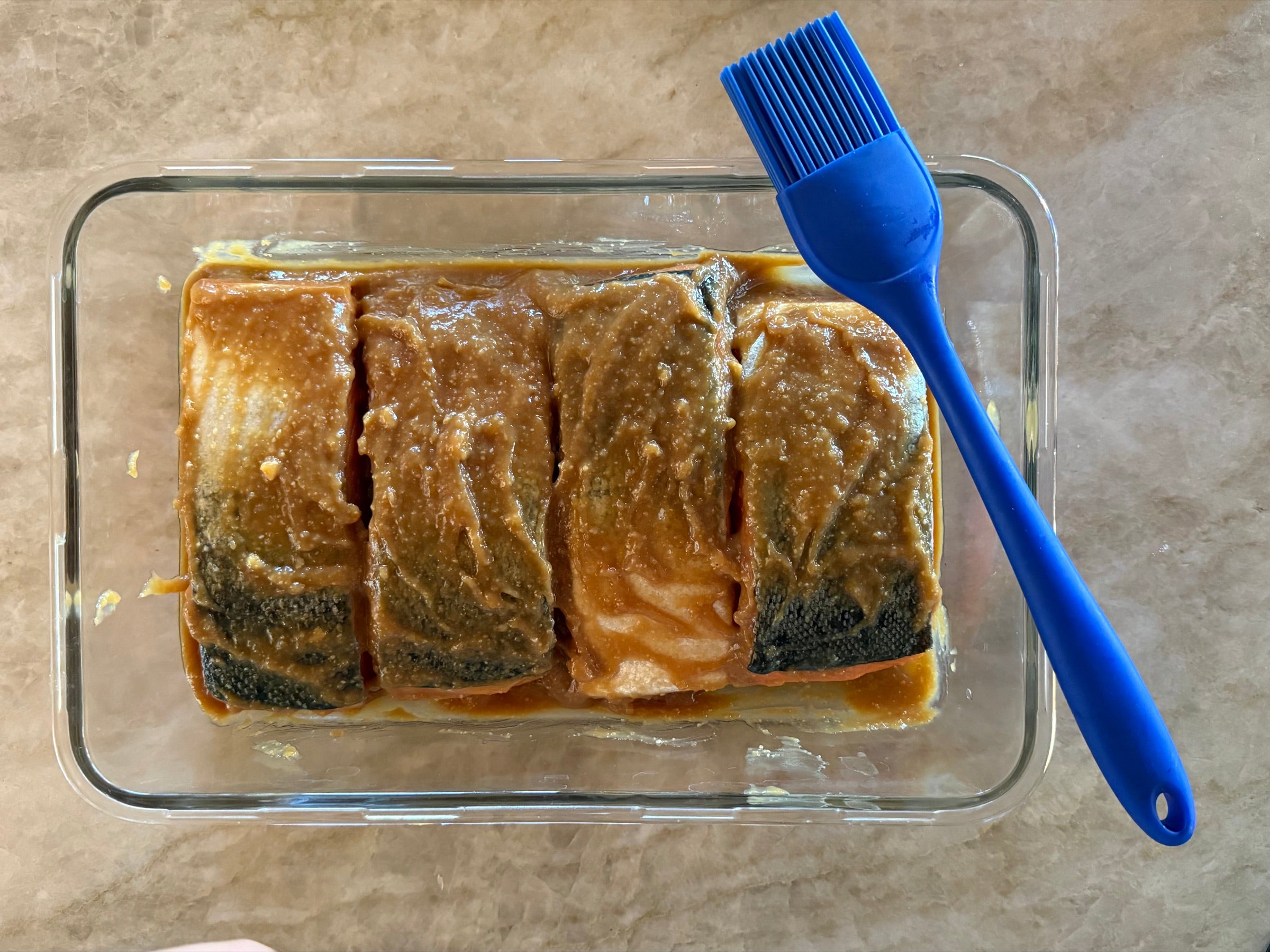 King salmon fillets submerged in cooled miso and sake marinade, ready for two days in the refrigerator