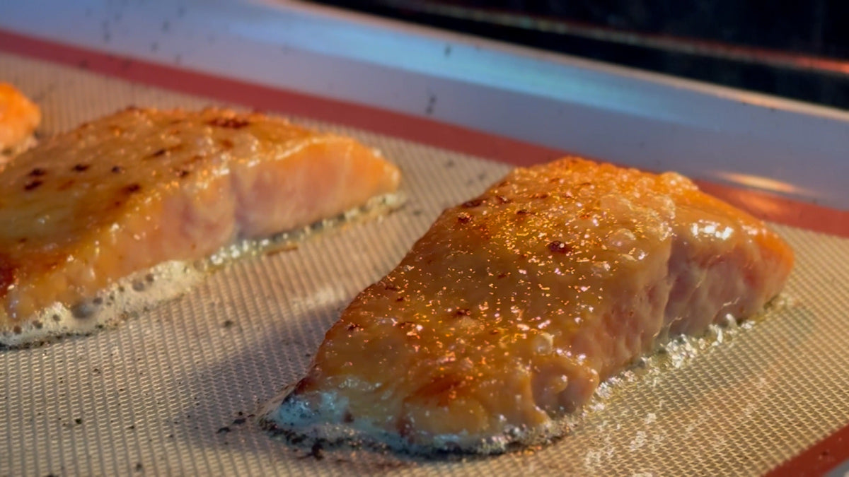 Miso-glazed salmon under the broiler, edges caramelising to deep golden brown